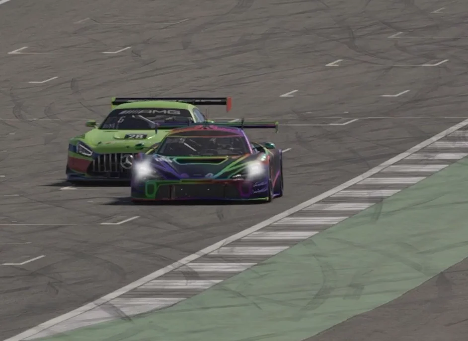 Rainbow McLaren GT3 defending inside line against green Mercedes-AMG GT3 #28 in close wheel-to-wheel battle on corner entry